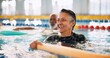 © CineLens2024/peopleimages.com - Swimming pool, senior people and woman with smile, exercise and water aerobics for fun. Pensioner, retirement and mature lady with fitness, wet and liquid with training, wellness and healthy with joy