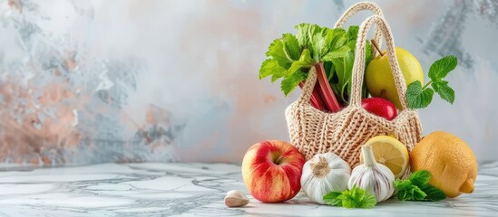 Sticker - Knitted bag filled with rhubarb lemon apples garlic and mint on a marble backdrop with copy space image