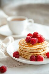 Wall Mural - pancakes with raspberries and a cup of tea. Selective focus