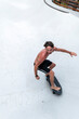 © Manu Prats - Shirtless skater in mid-turn on skatepark
