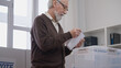 © Synthex🇺🇦 - Senior man casting a ballot in a transparent container and smiling, hope for the future