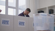 © Synthex🇺🇦 - Middle-aged man voting at a polling station, presidential election day, democracy