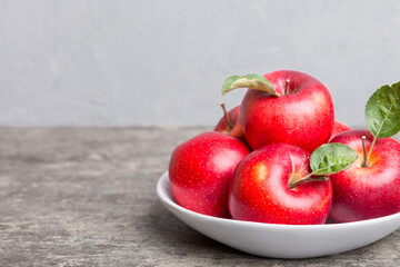 Wall Mural - juicy red apples in a bowl or plate on the table top view. Copy space