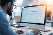 © zamuruev - Focused and dedicated professional intently analyzing data presented on his computer screen within a modern and stylish workspace