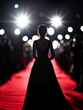 © alfa27 - A woman stands on a red carpet in front of a spotlight