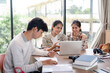 © Natee Meepian - Group of Student Collaboration on a Project in a Modern Study Space with Laptops and Books