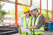 © JU.STOCKER - Engineer team in hardhats discussing on construction site, Engineer and female foreman worker with digital tablet checking project at the precast concrete factory site