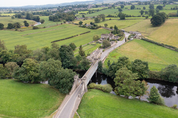 Aerial drone photo of the beautiful town of Middleham in Leyburn in North Yorkshire in the UK showing the British countryside and a famous historical bridge going into the town