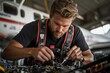 © Milos - A focused technician wearing a harness and working on the electronic systems of an aircraft inside a hangar, surrounded by various tools and components.