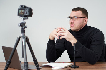 man filming video blog on camera with tripod for online followers. communication and internet concept