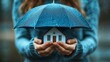 © Pravinrus - person holding an umbrella over a house, symbolizing the concept of home insurance and protection