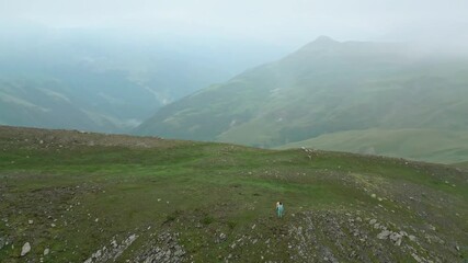 Poster - Aerial top view panorama solo caucasian woman hiker backpacker stand on viewpoint in caucasus mountains. Sakori lake hiking trail. Woman challenge discovery achievement reaching the top