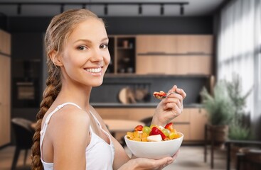 Wall Mural - Athletic young woman eating a fruit bowl