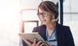 © peopleimages.com - Business woman, research and reading with tablet for news, data or study on corporate development at office. Young female person or employee with glasses on technology for company overview or report