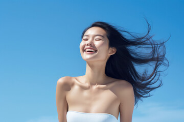 Wall Mural - Asian model with beautiful skin on a blue background exuding confidence and elegance, perfect for advertising