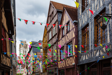 Wall Mural - Rouen, Normandy, France, Damiette street, famous for antique shops, traditional colorful half-timbered houses, narrow street, Saint Ouen Abbey  and flag decoration during Armada tall ship festival
