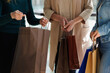 © Oleksii Syrotkin/Stocksy - Cropped of grandmother, mother and daughter with bags after shopping