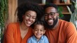 © Stone Story - Happy family portrait with mother, father, and child smiling indoors, wearing matching outfits. Cozy home environment with plants in the background.