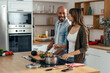 © nenetus - Happy beautiful couple cooking together in the kitchen at home