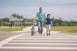 © Volodymyr - Safety on road. Pedestrian crossing for cyclists. Child in safety helmet with father riding bike in summer day. Fatherhood. Support parent. Fathers day. Child care. Fathers day. Insurance child.