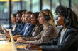 © Igor - Group of young business customer service people working together in call center office. Focus on young blonde woman with headset talking to customer.