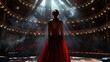 © Business Pics - From the back of the concert hall stage, an opera singer in a stunning red dress stands, her presence captivating even from behind as she prepares to grace the audience with her performance.