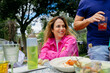 © Eloisa Ramos/Stocksy - Woman smiling at outdoor meal