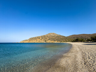 Wall Mural - Beach in Greece. Clear sea water and wet small pebbles. Summer holiday