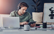 © peopleimages.com - Typing, online and man with tablet, office and laptop for project of video editor and headphones. Intern, morning and creative for business with sound, digital and planning in app, audio and person