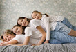 © Irina Ozhigova/Stocksy - Happy Family of Four Relaxing on Bed in Home