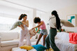 © BONNINSTUDIO/Stocksy - Joyful friends having a pillow fight at home