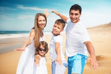 Canvas Print - Happy young parents and children on the beach