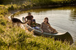 © Iuliia Versta/Stocksy - happy family canoeing on a lake with a pet