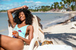 © David Prado/Stocksy - Young black woman relaxing on a sunny beach