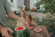 © Anna Artemenko/Stocksy - father cuts watermelon for children