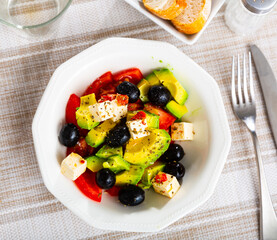 Sticker - Portion of fresh avocado salad with feta cheese, tomatoes and black olives.