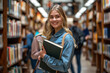 © GraysonStock - a young female college student standing holding a book in a bookstore