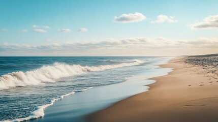 Wall Mural - Beautiful panoramic shot of a sandy beach with gentle sea waves lapping at the shore, showcasing a serene landscape.