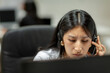 © Jimena Roquero/Stocksy - Woman with headset in office in front of computer