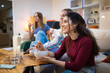 © Pedro Merino/Stocksy - Friends having dinner while watching TV at home