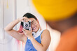 © VICTOR TORRES/Stocksy - Cheerful asian woman capturing a candid moment with vintage camera