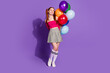 © deagreez - Full length photo of shiny dreamy lady dressed off shoulders top rising balloons bouquet look empty space isolated violet color background