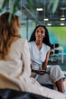 © BONNINSTUDIO/Stocksy - Businesswomen having a meeting using a tablet in a modern office