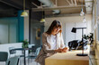 © BONNINSTUDIO/Stocksy - Businesswoman using smartphone in modern office cafeteria