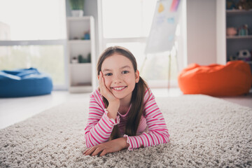 Poster - Full body photo of cute small schoolgirl lying floor soft carpet dreamy relaxed home education school interior