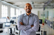 © BONNINSTUDIO/Stocksy - Confident business manager smiling with arms crossed in office