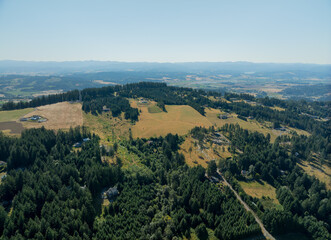 Top view of a mountainous area with houses and forest. Light blue sky. Ecology, environmental protection. There are no people in the photo.