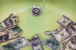 © Nata Segueza/Stocksy - Money Going Down The Drain