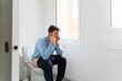© Alba Vitta/Stocksy - Man sitting on toilet in bathroom