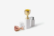 © Yaroslav Danylchenko/Stocksy - Winner gold cup standing on stand while silver and bronze lying near